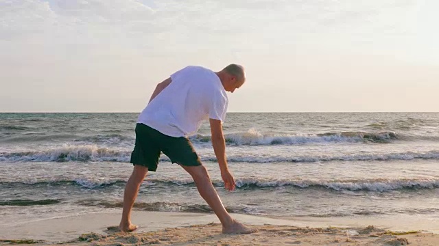 一个成年人在海滩上练习瑜伽姿势。在空旷的海滩上进行瑜伽训练视频素材