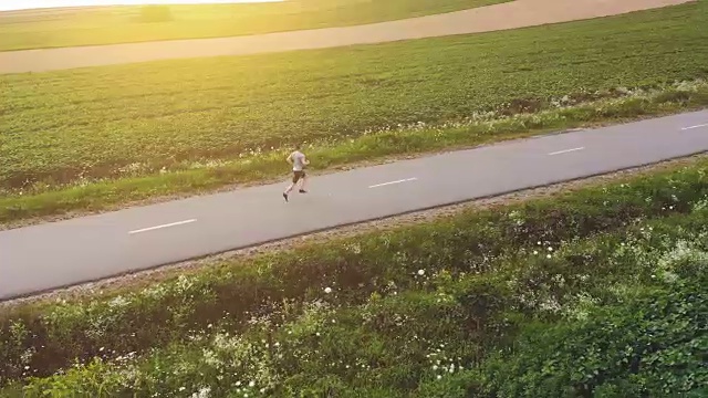 那个运动员在路上慢跑。quadrocopter拍摄视频素材