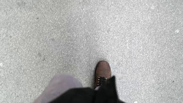 一个穿着靴子走在街上的男人。从行人角度向下看的脚视频素材