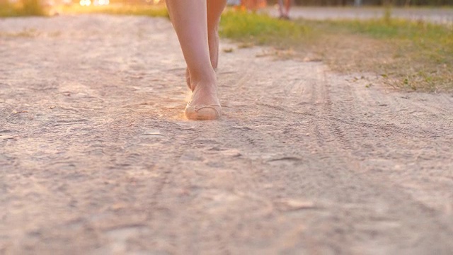 穿着平底鞋的女人的脚走在尘土飞扬的小路上视频下载