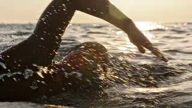 男子游泳运动员在阳光下在海上游自由泳视频素材