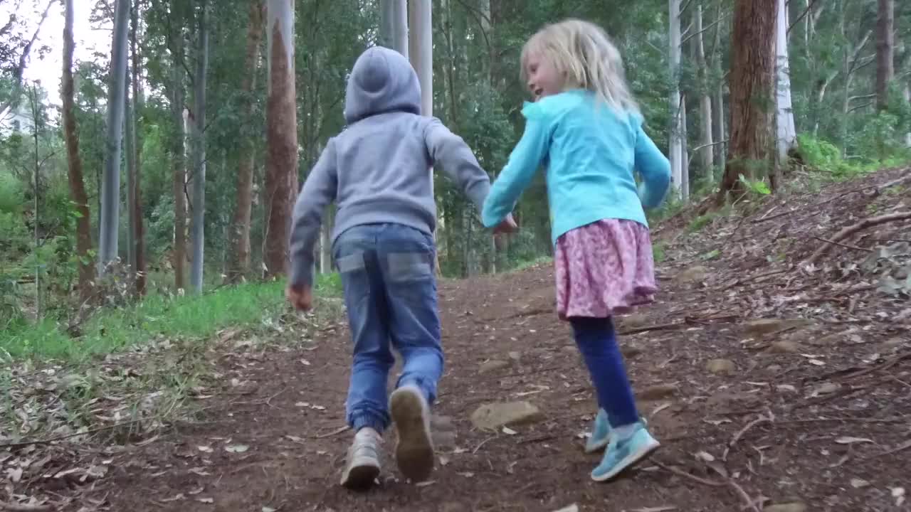 兄妹俩在郁郁葱葱的森林里奔跑视频下载