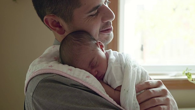 刚出生的小女孩睡在她父亲的肩膀上视频下载
