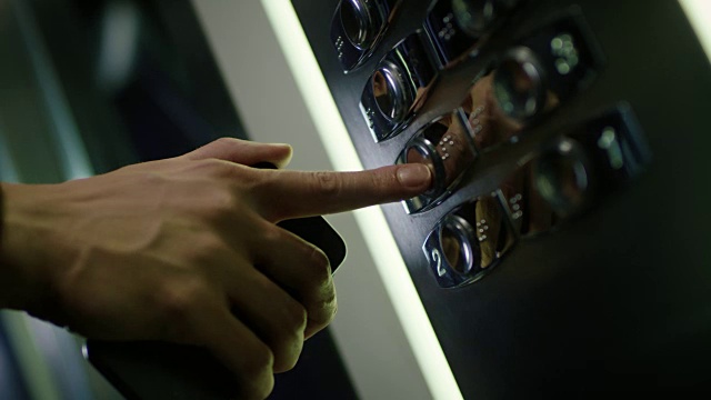男手在电梯内按楼层数按钮。人类的手指压视频下载