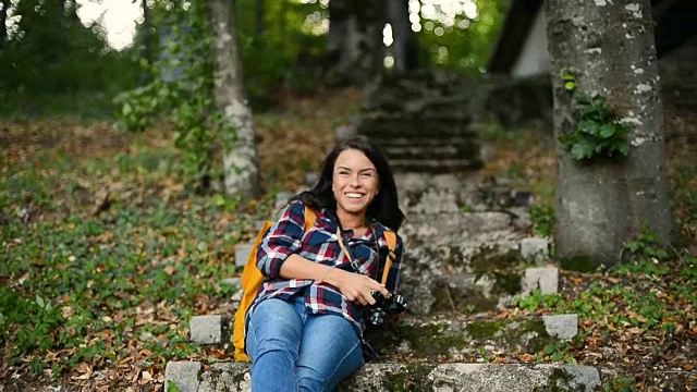 女徒步旅行者在森林里与相机享受生活和她的收费时间视频素材
