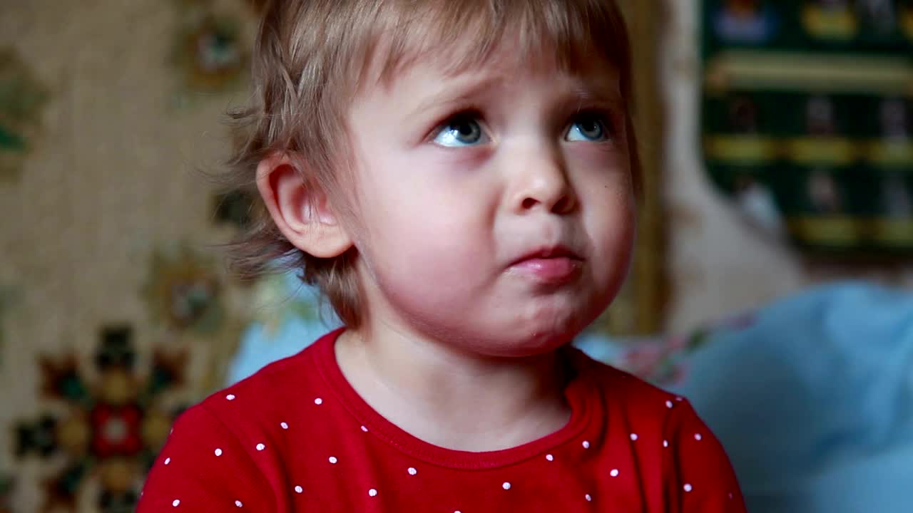 一个婴儿嚼着饼干指着右边的特写视频素材