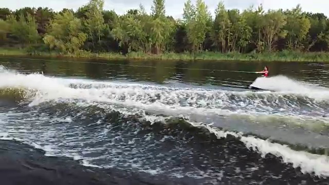 飞行近水上滑水板冲浪在高速。湖上滑水的鸟瞰图。视频素材
