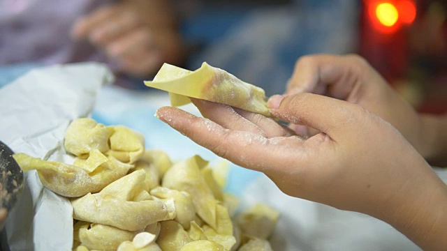 亚洲妇女手工制作馄饨和饺子馅。视频素材