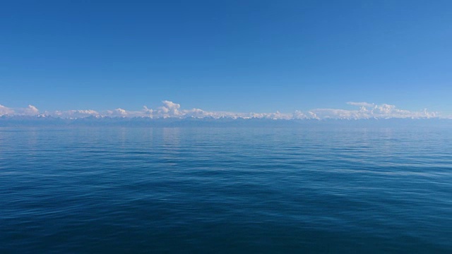 蓝色的湖伊塞克库尔在背景雪山山峰在吉尔吉斯斯坦视频下载