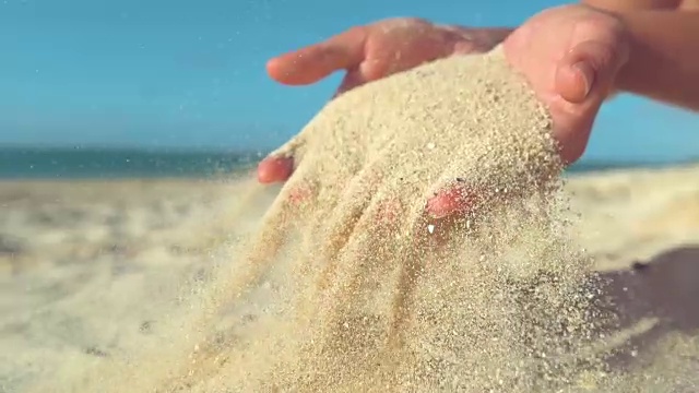 一名不知名的女游客在沙滩上玩沙子视频素材