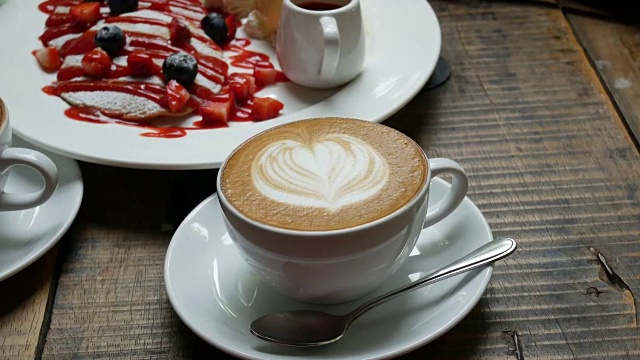 早上在木桌上放一杯卡布奇诺咖啡。视频下载