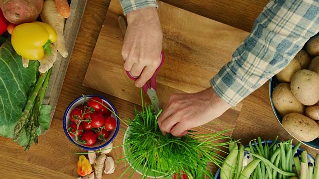 男人的手在厨房的砧板上切鲜韭菜视频素材