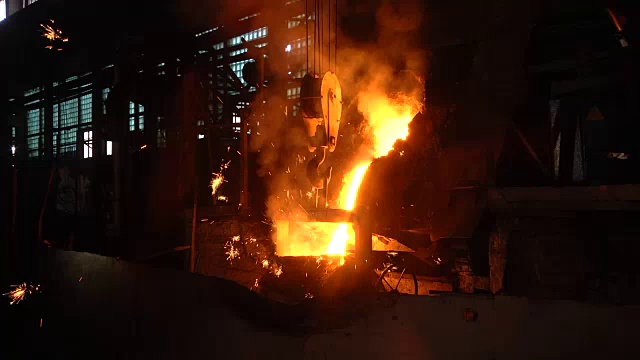 生产部门铸造在烧瓶中。通过铸造制造金属产品的空间。气化模型铸造车间。熔化的金属从感应炉倒入钢包。热金属的火花飞溅开来。视频下载