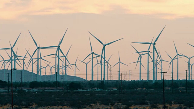 Pan:风力涡轮机在日落沙漠中移动(拍摄于RED)视频素材