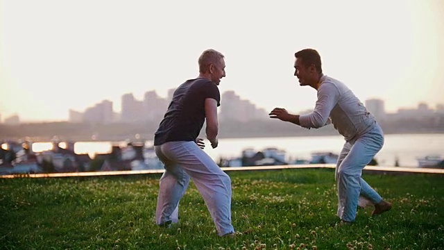 夏天，两个壮汉在草地上表演卡泼卫拉摔跤视频素材