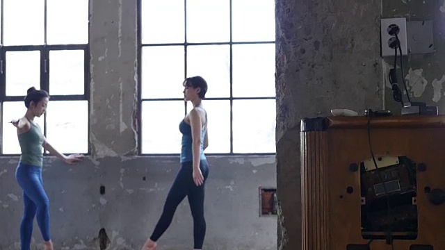 年轻女性穿着瑜伽服站在室内伸展身体视频素材