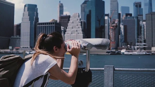 快乐的女旅行者透过高楼观看史诗般的阳光城市天际线，纽约曼哈顿，慢镜头视频素材