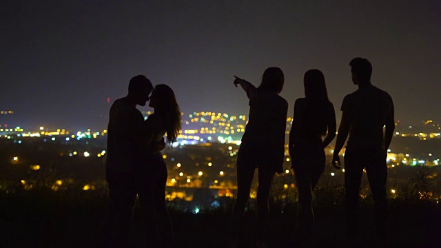 这五个人站在城市灯光的背景上。晚上晚上时间视频素材