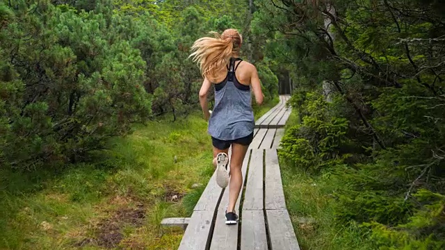健康女性运动员在大自然中跑步穿过树林视频下载