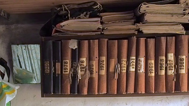 书架上有棕色的旧书，近距离观看。摄像机沿着挂在小屋墙上的书架移动。木架上一排一排的古书视频素材