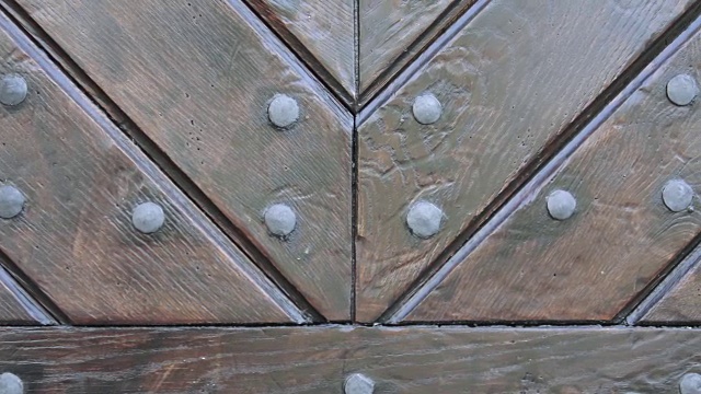 质朴的棕色木门纹理。带有金属铆钉的木门碎片。旧木门的质感视频素材