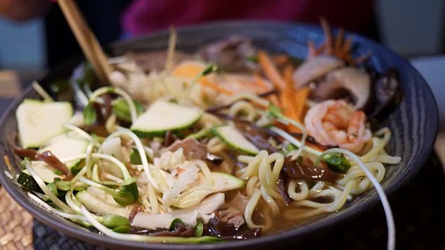 拉面是一种传统的日本汤，里面有虾、肉、蔬菜和面条。4 k视频素材