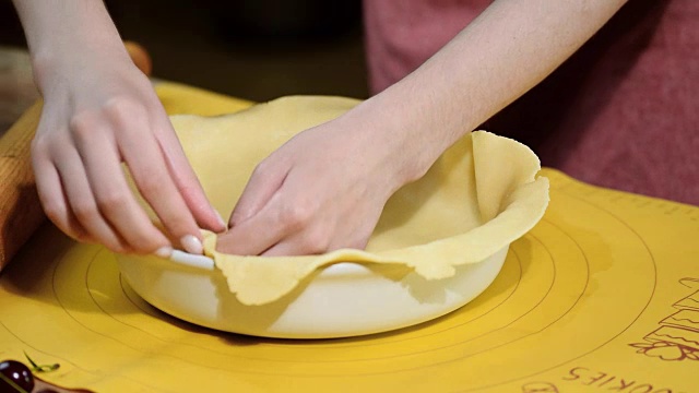 烹饪概念。女人把新鲜的生面团烤成面包状，特写。视频素材