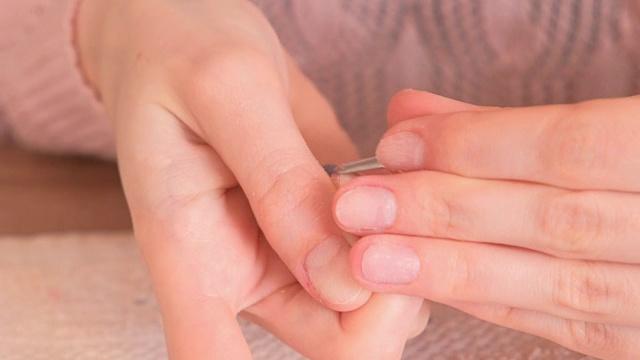 妇女用推子去除指甲上的虫胶。特写镜头。视频下载