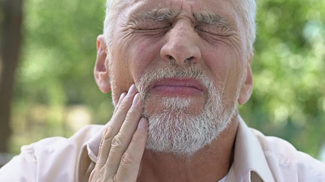 退休男子忍受着牙痛，植牙不适，牙科护理视频素材