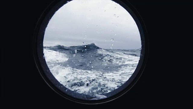 从波涛汹涌的海面上一艘船的舷窗里视频素材