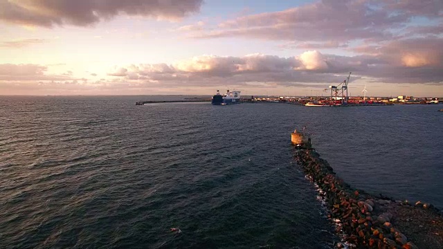 日落时海岸及货柜码头鸟瞰图。码头上的船视频素材