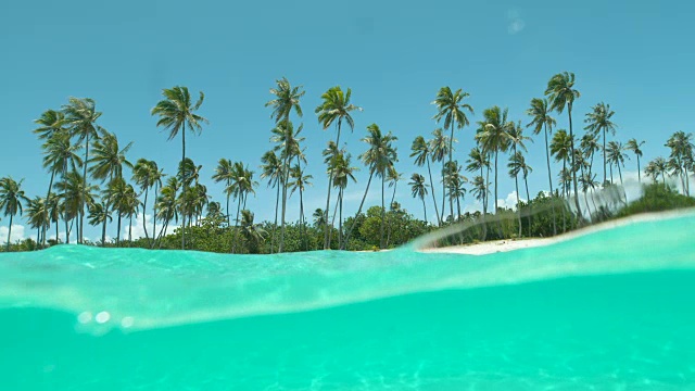 慢镜头:清澈的海水流过摄像机拍摄的热带海滩。视频素材