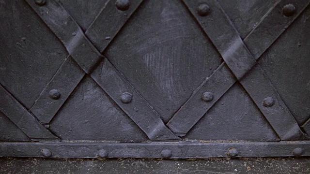 一扇老式的黑色金属门，用镶板加固。视频素材