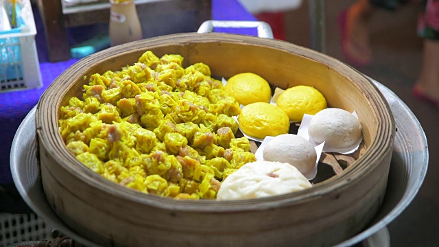 在泰国曼谷的一家小餐馆的中国步行街上出售的刚煮好的馒头和饺子视频素材