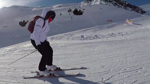 在平缓山坡上的滑雪者推着他的滑雪棒往下滑视频素材