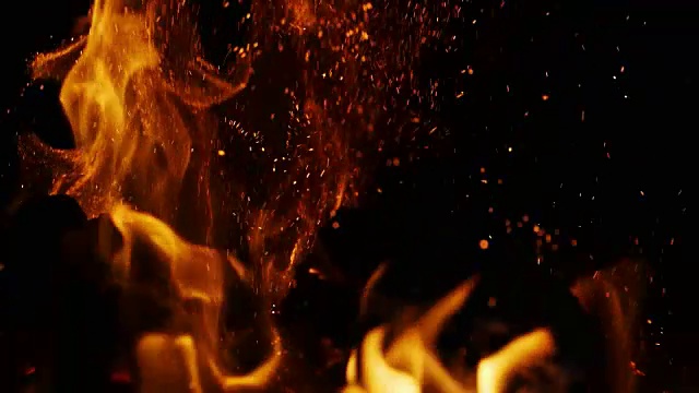 火焰火花移动在黑暗的黑色背景从明亮燃烧温暖视频下载