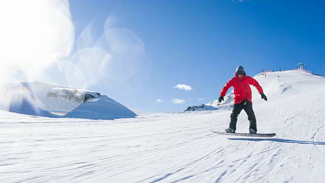 在一个阳光明媚的日子里，以滑雪缆车为背景，从滑雪坡上滑下视频素材
