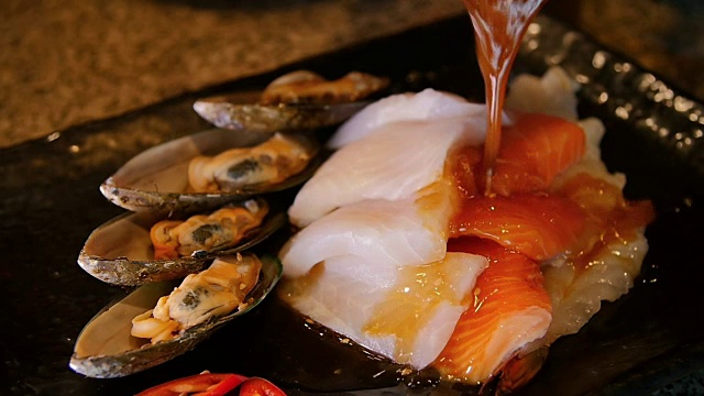 韩式芝麻酱淋在鲑鱼，鳕鱼，贻贝上。准备烧烤。视频下载