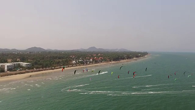 在泰国普兰武里亮蓝色的水面上进行风筝滑板比赛时彩色风筝的鸟瞰图视频素材
