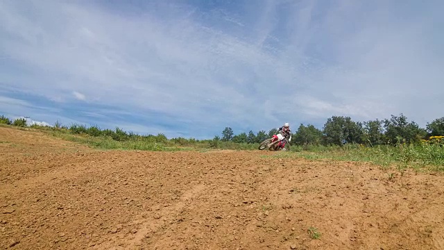 越野摩托车手在土路上跳跃视频素材