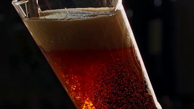 冰镇啤酒倒入高脚杯的慢动作视频下载