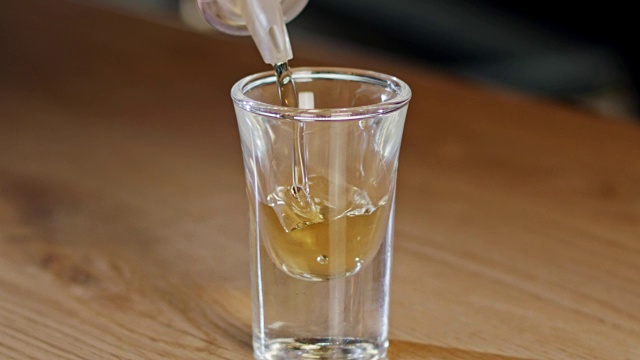 一杯威士忌倒入玻璃杯的慢动作视频下载