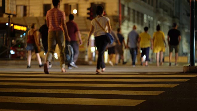 人们穿越街道。意大利罗马夜晚，行人穿过人行横道视频素材