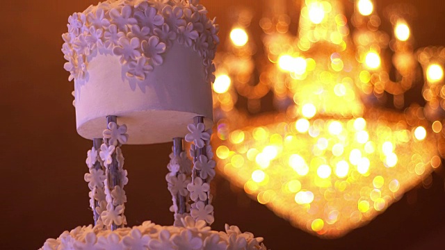 美丽的白色婚礼蛋糕与吊灯的背景与复制空间视频素材