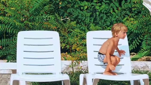泳池边快乐的小男孩。视频素材