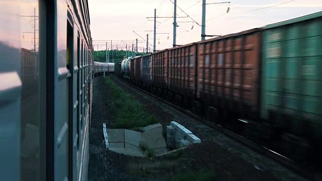 从移动的火车上射击。在相反的方向上有一列货运列车经过附近的铁路视频素材