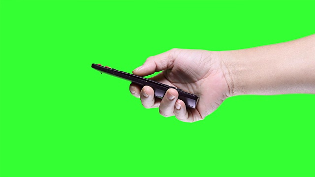 手握遥控器隔离在绿色屏幕的背景。视频下载