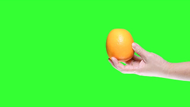 手握橙色孤立在绿色屏幕背景视频素材