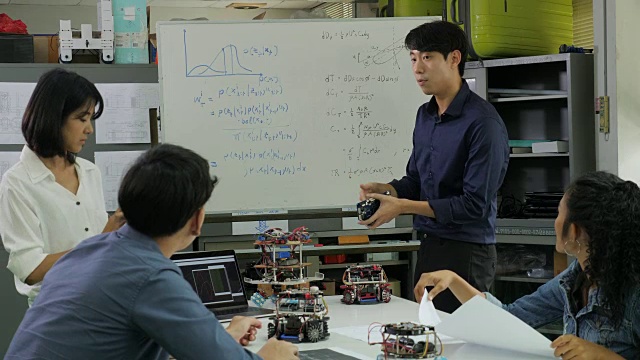 在计算机科学课上，老师与学生谈论机器人技术。男工程师与团队一起参与项目。有技术或创新观念的人。视频素材