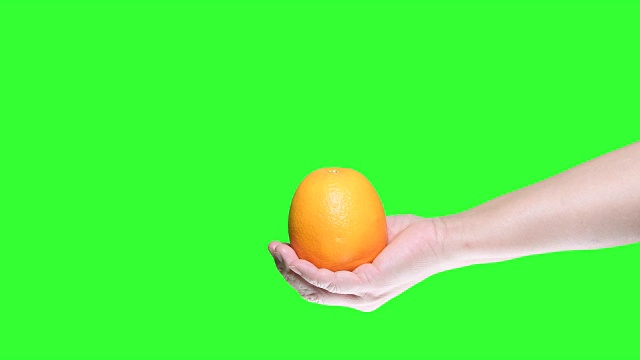 手握橙色孤立在绿色屏幕背景视频下载